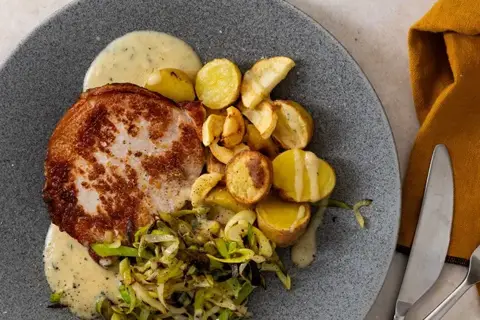 Sennepstegt svinekotelet med smørstegt porre og estragonsauce