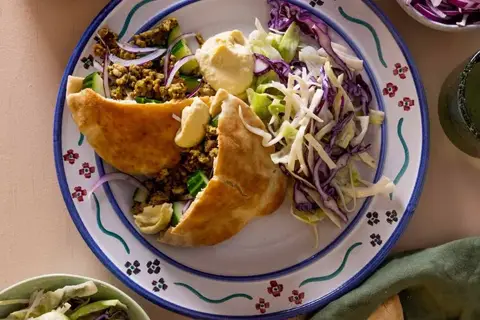 Pitabrød med krydret svinekød, kålsalat og hummus