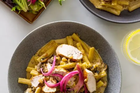 Kyllingefilet og cremet svampepasta med salat og syltede rødløg