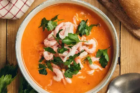 Peberfrugtsuppe med rejer serveret med aioli, persille og brød