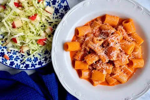 Pasta med gris i cremet tomatsauce med kålsalat