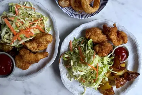 Sprød kylling med løgringe, ketchup og coleslaw