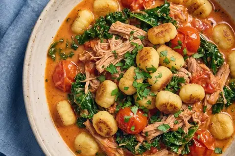 Svinekød i cremet tomatsauce med stegt gnocchi og persille