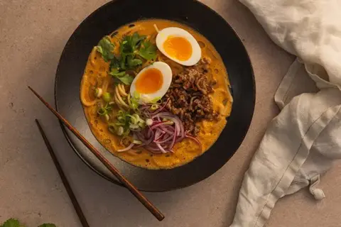 Massaman curry ramen med stegt svinekød og blødkogte æg