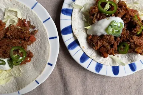 Wrap med krydret oksekød, salat og creme fraiche