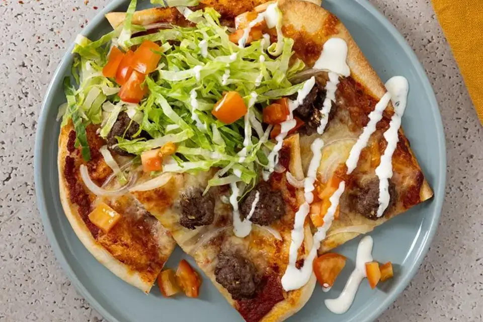 Pizza med oksekød, salat og dressing — RetNemts eget foto