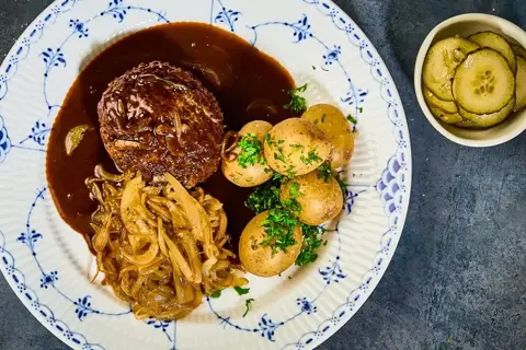 Klassisk hakkebøf med bløde løg, pandesovs, agurkesalat & hvide kartofler