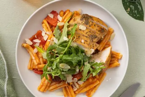 Pasta i romescosauce med kyllingebryst, rucola og mandler