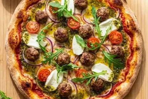 Pizza med spicy kødboller, frisk mozzarella, grøn pesto og rucola