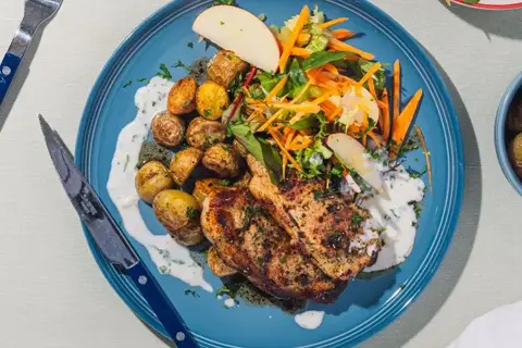 Svinekoteletter med persillesauce, krydderkartofler og æblesalat