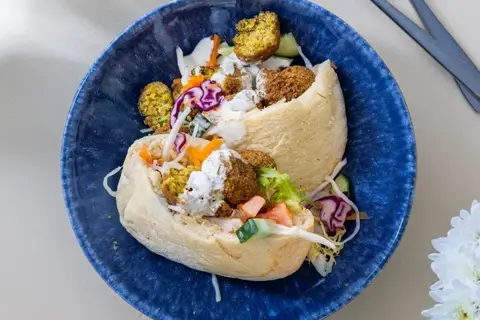 Falafel i pita med grønt, syltet kål og hvidløgsdressing
