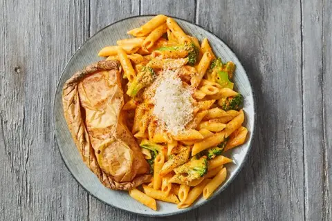 Citronbagt laks en papilotte med broccoli og penne i peberfrugtsauce
