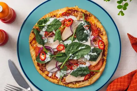 Italiensk pizza med røget kyllingebryst, tomat, rødløg og spinat