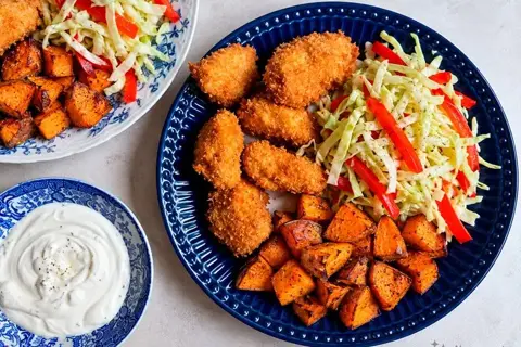 Kyllingenuggets med søde kartofler og kålsalat