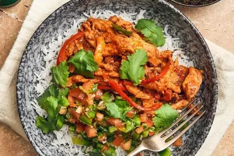 Carnitabowl med marinerede svinestrimler med ris, salsa, lime og koriander