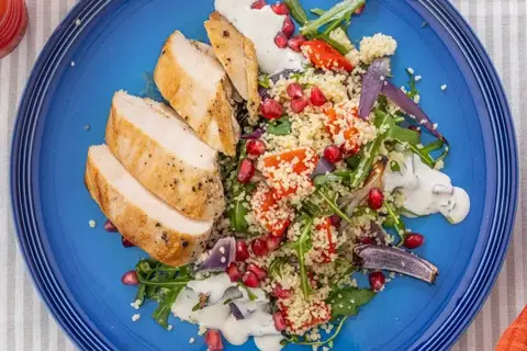 Ovnbagt kyllingebryst med couscoussalat, granatæble, rucola og urtedressing