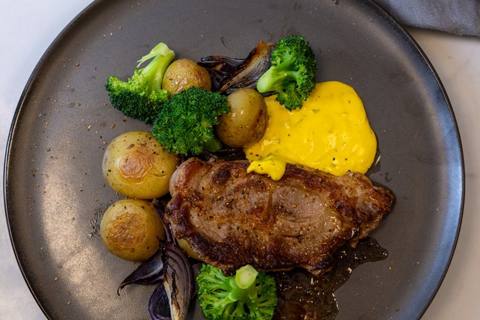 Citruskrydrede koteletter med ovnbagte kartofler, løg, broccoli og bearnaisesauce