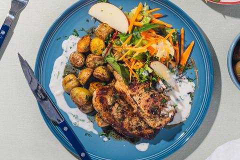 Svinekoteletter med persillesauce, krydderkartofler og æblesalat